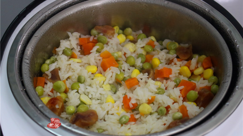 蔬菜腊肠饭,烹调结束,关掉电源,用饭勺打散米饭,撒点葱花拌匀,舀起即可食用