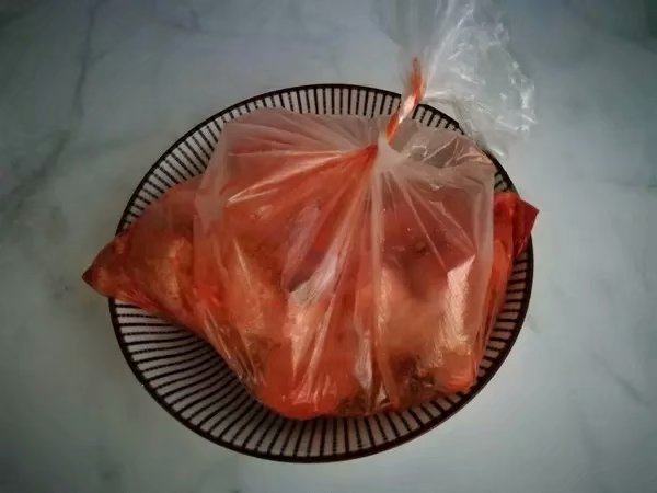 韩式泡菜风味烤翅根, 把鸡翅根洗净,用叉子扎几下,放入保鲜袋中,倒入搅拌好的腌肉料,打个结,用手抓匀,腌制4个小时以上。