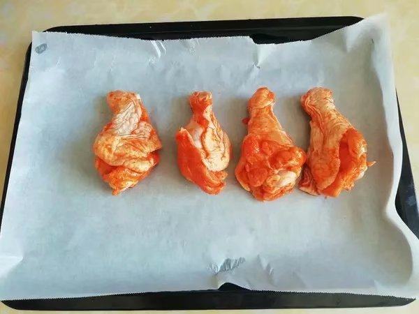 韩式泡菜风味烤翅根, 烤盘铺上油纸,摆上鸡翅根,放入预热好的烤箱中层,200度烤十分钟。