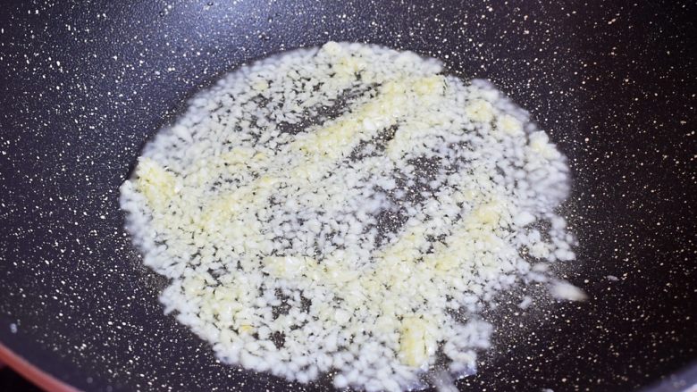 蒜蓉粉丝蒸扇贝,再来制作蒜蓉豉油,锅中倒入适量的食用油烧热,放入一半的蒜蓉