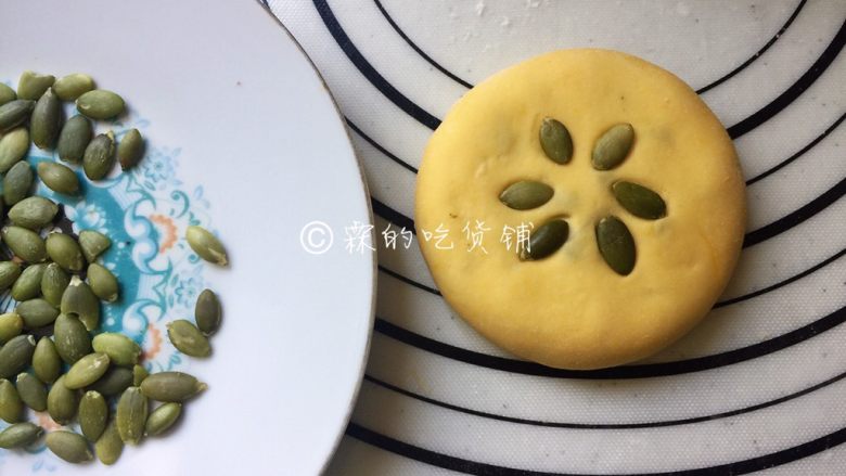 奶香南瓜蜜红豆馅发面饼,收口后，稍稍按扁，表面可加上南瓜子仁点缀一下，随后再次醒发15分钟左右。