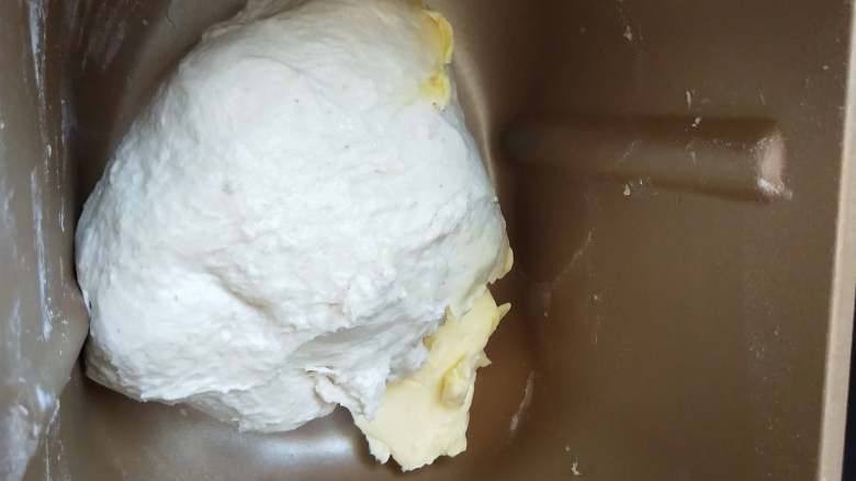 全麦豆沙软欧,、揉成团后加入软化的黄油继续揉。