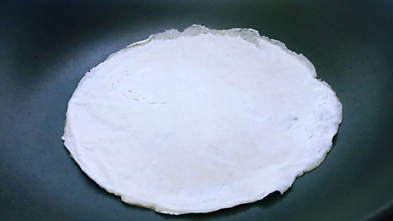 手抓饼,平底不粘锅烧热之后,饼片直接放入锅中,不需要放油,也不需要盐,小火,期间每隔2~3秒钟来回转动翻面,两面都煎呈金黄色时。如果想要饼蓬松一点就用筷子或者铲铲子,由4周往中间拍打,同时挤压让其蓬松就可以了。