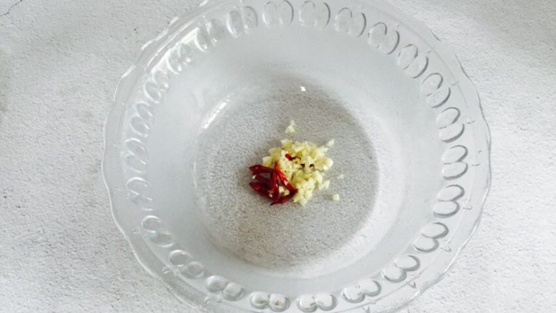 野生淡干虾皮拌卷心菜,取一个大一点的容器,放入蒜末、辣椒