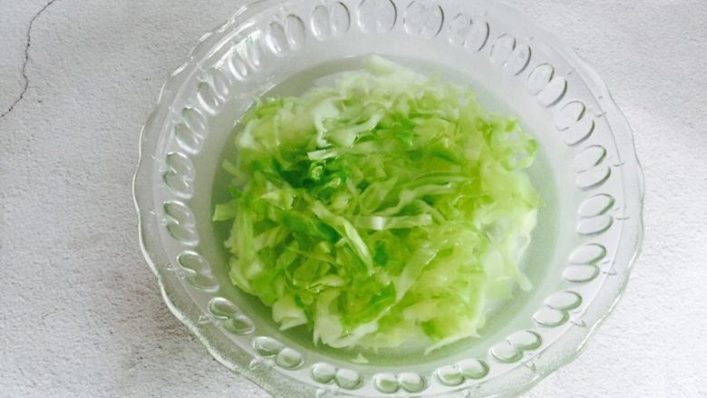 野生淡干虾皮拌卷心菜,捞起放入提前备好的凉水,待凉拌时沥干水分