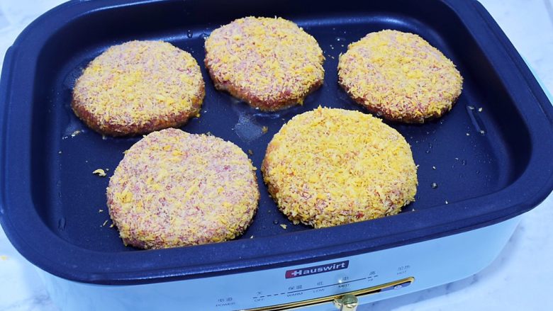 猪排汉堡包,平底锅倒入适量的食用油烧热,放入肉饼,小火煎至金黄色再翻另一面继续小火煎至金黄色