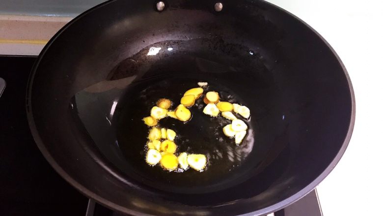 火爆香辣鸭心,油烧热后加入蒜片和姜片,炒出香味