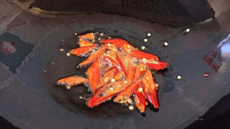 孜然羊肉,油锅烧热,放入红辣椒爆香