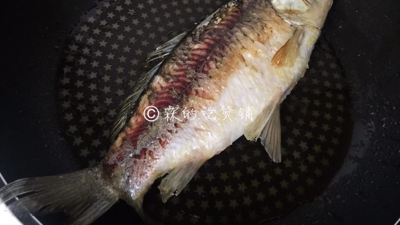 葱烤鲫鱼,一面煎牢,翻面继续,二面都煎好,盛出。