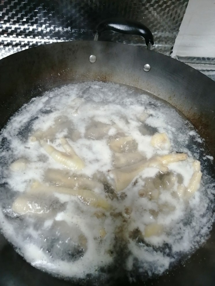 超级受欢迎的香辣凤爪,煮出浮沫,然后将鸡爪捞出,放凉水里冲洗干净。