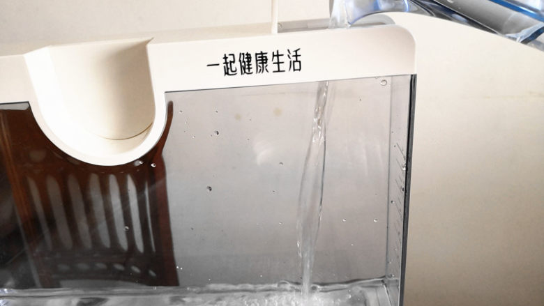 凉拌茄子,上锅将其蒸熟,这里用的是用电的蒸气料理机,所以要先将水箱注入一定量的纯净水,