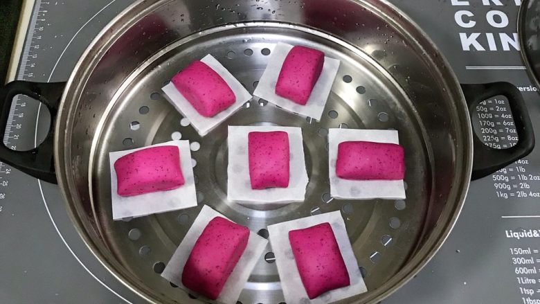 火龙果馒头,切好的馒头放在油纸上,切好的馒头放在油纸上,冷水上锅发酵1.5倍大。