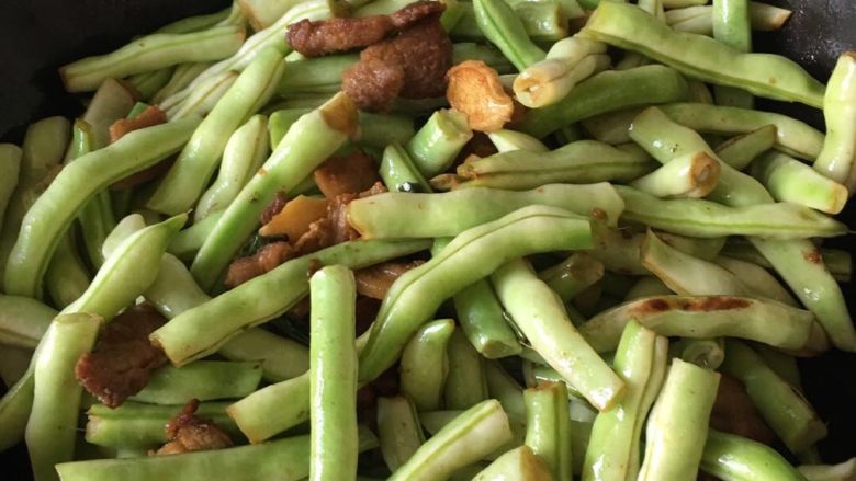 五花肉炖芸豆,倒入豆角,翻炒至豆角颜色变绿