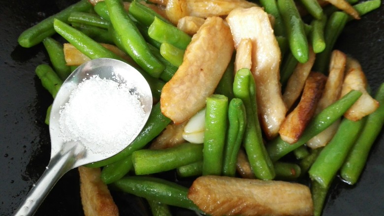 猪颈肉炒四季豆,放入四季豆一同翻炒,加入一勺盐调味