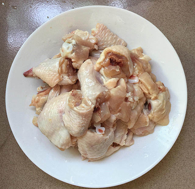 泰式香辣风味烧鸡翅,鸡全翅用料酒水浸泡1小时,中途换水2~3回。泡出血水的鸡翅,剁成小块。