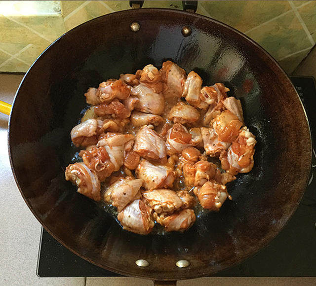 泰式香辣风味烧鸡翅,炒锅加注入食用油,下姜片爆锅后下腌好的鸡翅