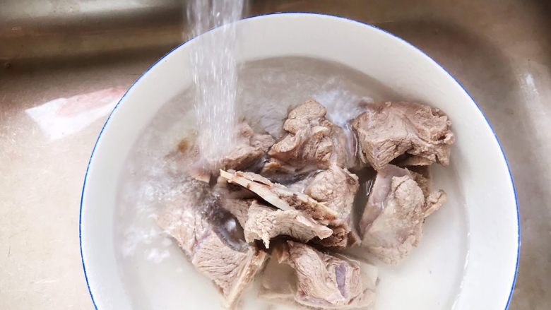 香菇黄豆腐竹烧排骨,捞出煮好的排骨,用流动水冲洗干净表面的浮沫