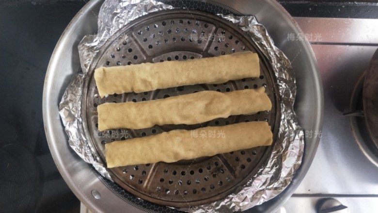 烟熏豆皮肉卷,把蒸锅的篦子放上面,再把豆腐卷摆上去。