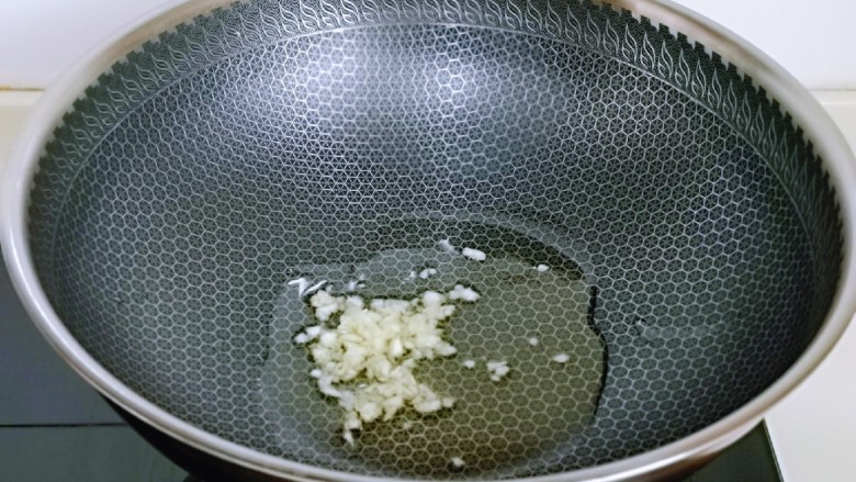 低脂茄汁鸡肉丁,起油锅,加入蒜末炒香。