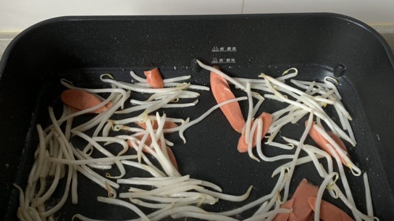 家常炒面,锅中倒少许油,下豆芽、火腿片翻炒几下