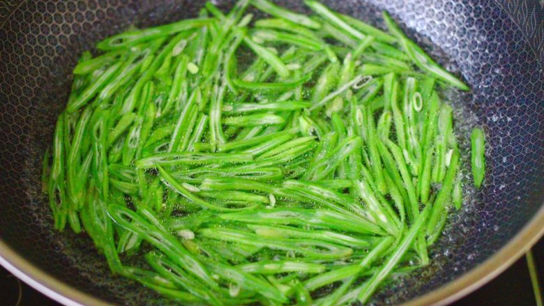 芸豆丝炒肉便当,锅中倒入适量清水煮沸后,加入少许盐和几滴食用油,把切丝的芸豆放入锅中进行焯水,开锅后把芸豆丝焯熟后捞出(有些人在吃蔬菜的时候喜欢吃生一些的,看上去绿油油的,吃起来口感脆脆的。但是芸豆并不适合这种吃法,夹生的都不能,必须要从里到外全部都煮透,不然会引起中毒现象,甚至严重的可能致死,所以一定要注意这一点。)