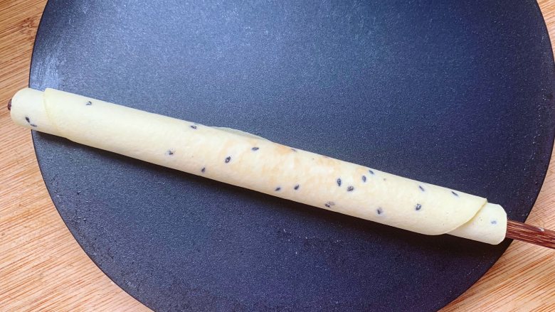 黑芝麻鸡蛋卷,速度要快一些,防止蛋卷皮降温变脆无法成型,操作的时候最好戴手套进行,以防烫伤手。