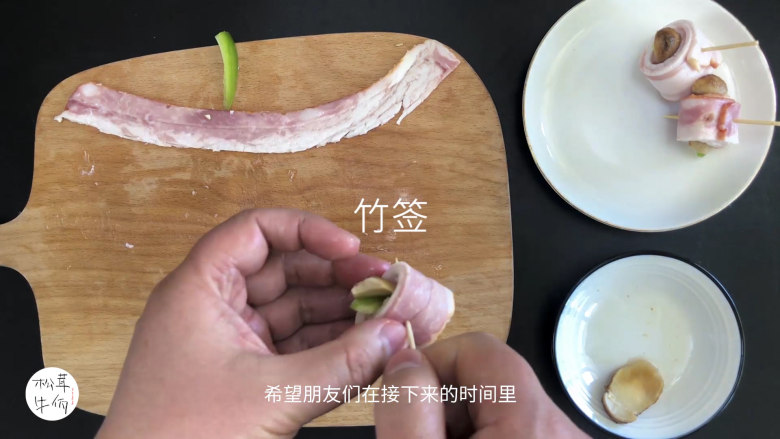 视频｜松茸培根卷｜牛佤松茸食谱,将培根铺开，在一端放上一片醒开的（牛佤）冻干松茸菌和甜椒，卷起后用竹签插入其中固定。