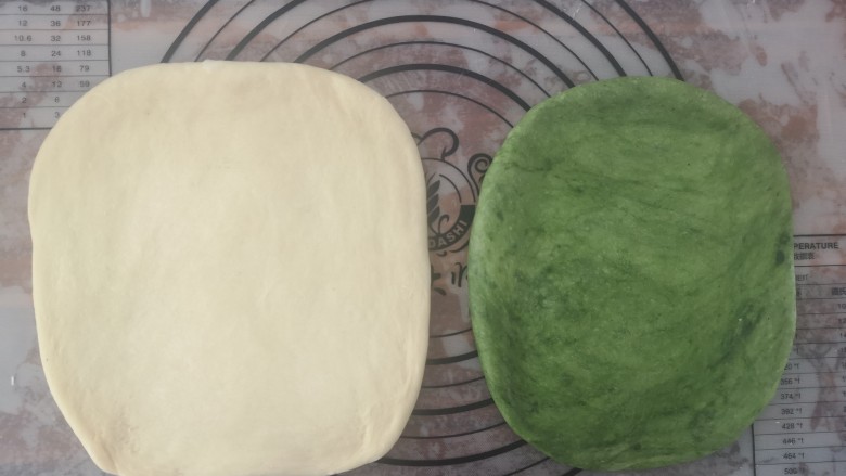 抹茶蜜豆土司,把两个面团擀成宽一点的长方形,原味面团比抹茶味的要稍微大一圈