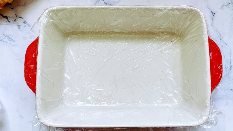 【酸奶水果条】,准备一个大一点的长方形容器,铺上一层保鲜膜,这样成品更好脱模。
