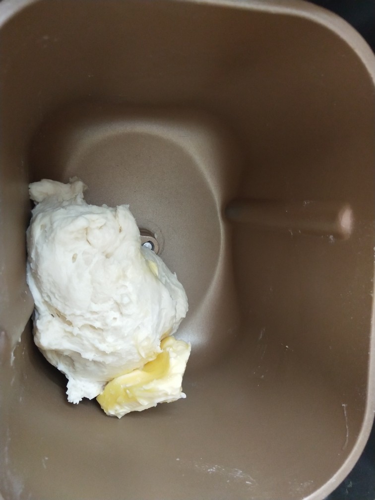 栗子红豆包,4、揉成团后加入软化的黄油继续揉。