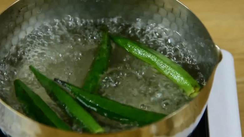 赶快,趁隔壁小孩还没馋哭,先吃了它,开水中加入盐,倒入秋葵煮1分钟。