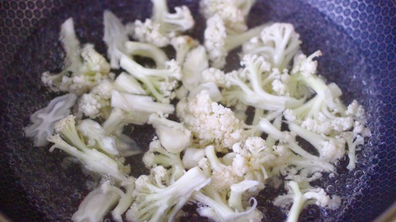 菜花番茄海虾小炒,锅中倒入适量清水煮沸后,放入菜花进行焯水,菜花煮至1分钟后,捞出沥干水分备用。