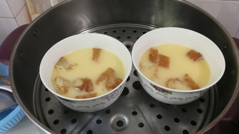 油条蒸鸡蛋,蒸锅水开放入鸡蛋碗,蒸八分钟焖三分钟
