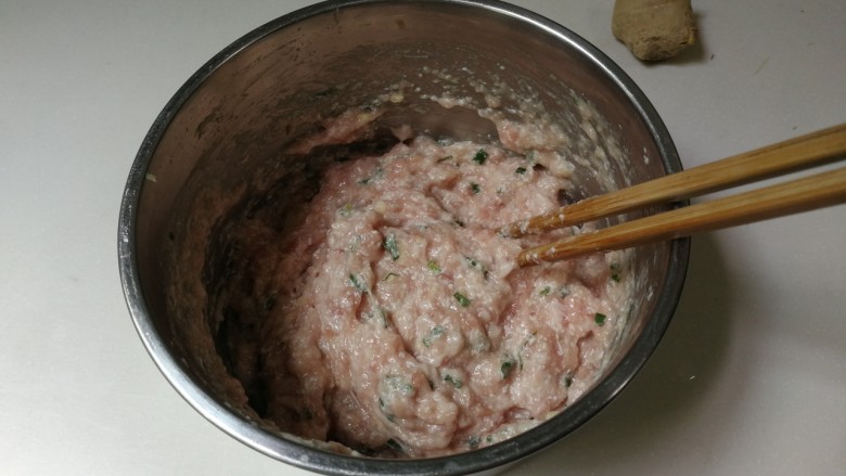 蚕豆冬瓜汆汤圆子,顺时针搅拌至有粘性的肉糊,用筷子挑肉糊摔打几下