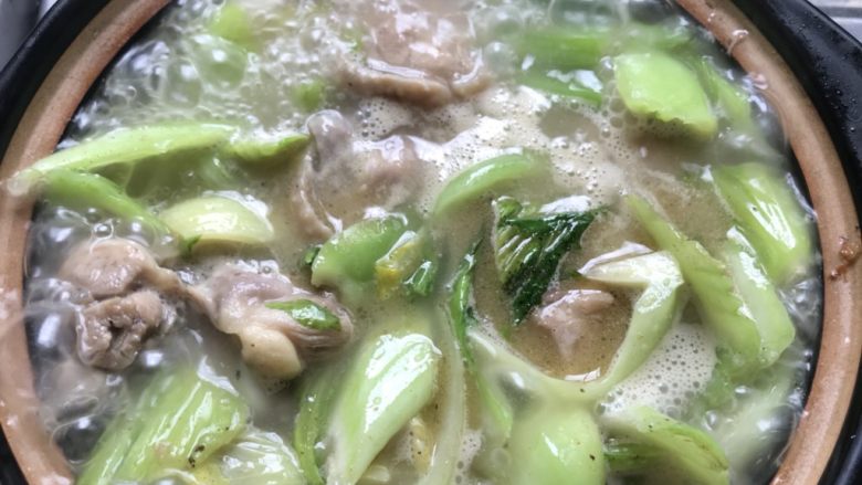 芥菜鸡汤,把食材倒入砂锅里,加入热水煮。