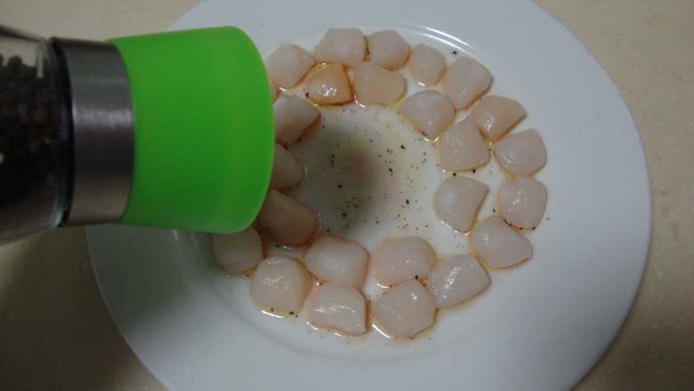 扇贝蔬菜沙拉,扇贝柱拍扁码在盘子里，围成一圈。撒上盐、黑胡椒碎