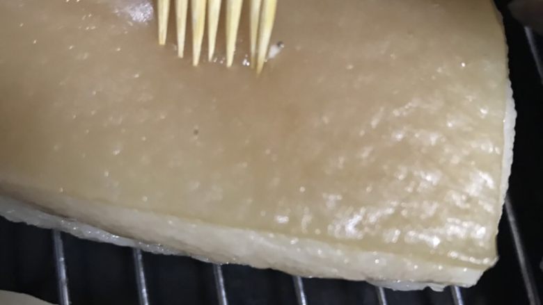 梅菜扣肉,牙签在肉皮上插孔,并且擦干插出来的油水。