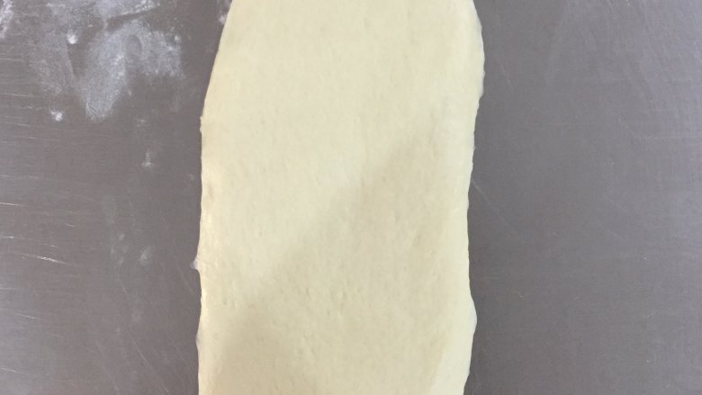 葡萄干吐司,松弛好的面团擀成长条,椭圆形。