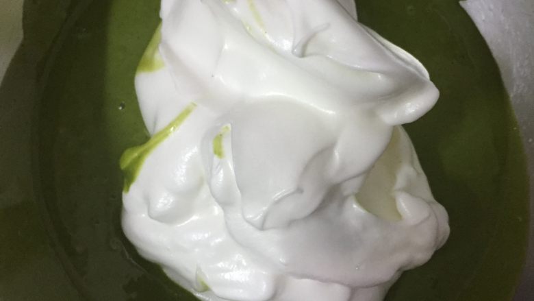 草莓抹茶卷,把3分之1的蛋白霜加入到面糊中,快速翻拌均匀。