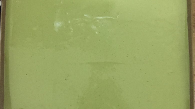 草莓抹茶卷,把拌好的面糊倒入垫了油布的烤盘中,刮平后震出大气泡。