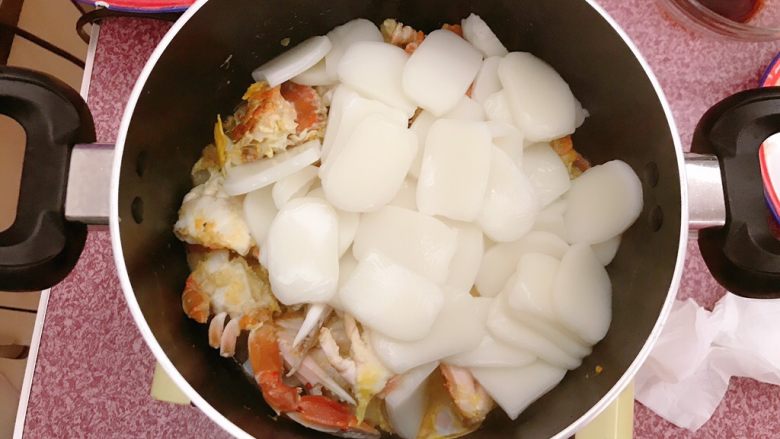 年糕蟹煲,鸡蛋全部凝固后,从水中捞出年糕,放入蟹中。
