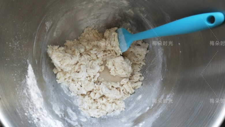 葱香肠仔包,先搅拌成棉絮状,然后撒酵母。这里用的酵母是即发型高活性耐高糖酵母。然后用手按压成团。