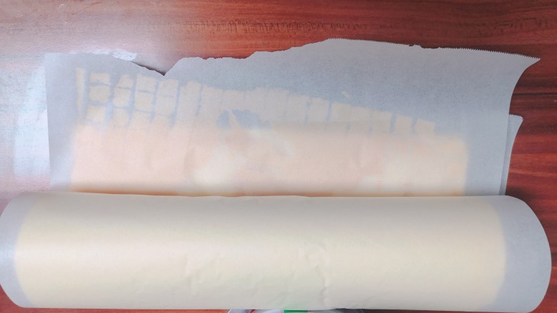 不易开裂的轻盈蛋糕卷,待蛋糕片到温热状态,把蛋糕片从烤盘轻轻揭起,把蛋糕片的两面都垫一张油纸,然后轻轻卷起,固定一下。