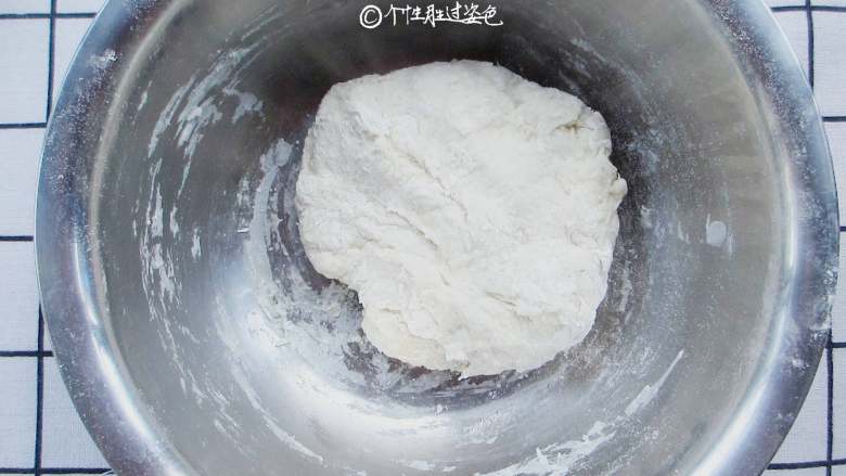 家常韭菜饼,用筷子搅成絮状,由于面粉吸水性不同,温水不要一次倒入,先倒入大半看情况再增减。揉成很软的面团,不用揉成很光滑,因为面团特别软,盖上保鲜膜发酵40分钟