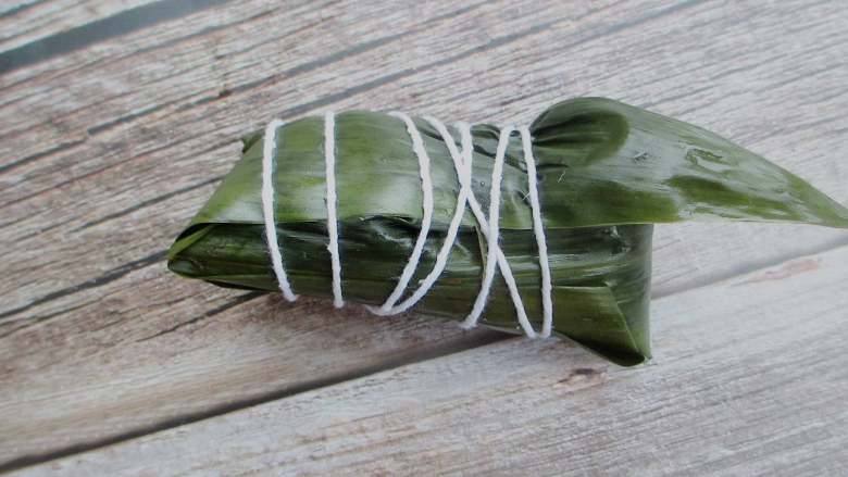 红糖红豆蜜枣粽,把粽子盖上,用大拇指按住,包好后用绳捆起来