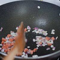 咖喱蛋包饭,先将锅烧热,倒入少许油,倒入部分洋葱丁和火腿丁,翻炒均匀