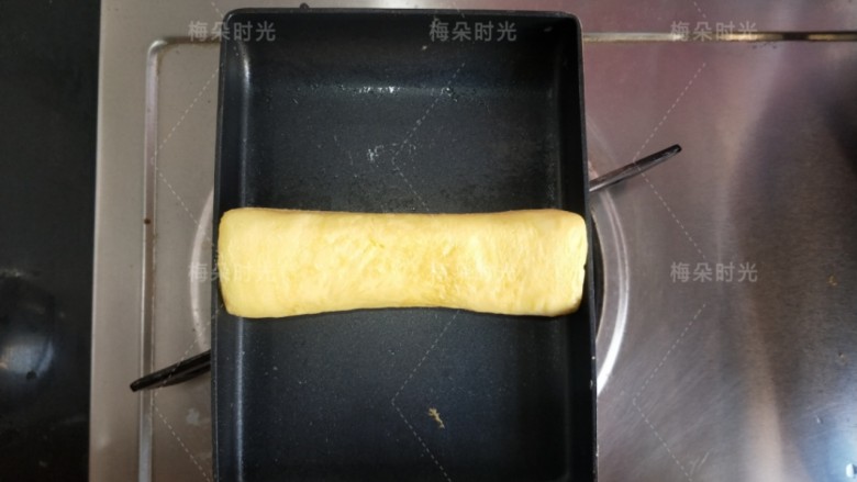 日式玉子烧,直到所有蛋液都用完,鸡蛋卷成一个圆柱型,然后再烙一下,表面有轻微的焦斑。