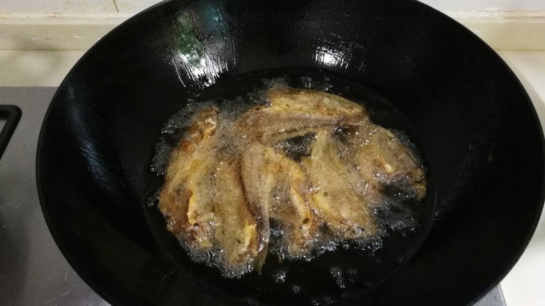 酥香小黄鱼,油锅再烧热,放入小黄鱼炸至金黄
