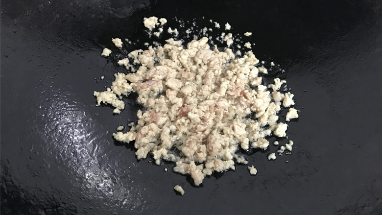香菇时蔬糯米饭,锅中倒入适量油,7成热,放入腌制好的肉末煸炒下至肉末变色。