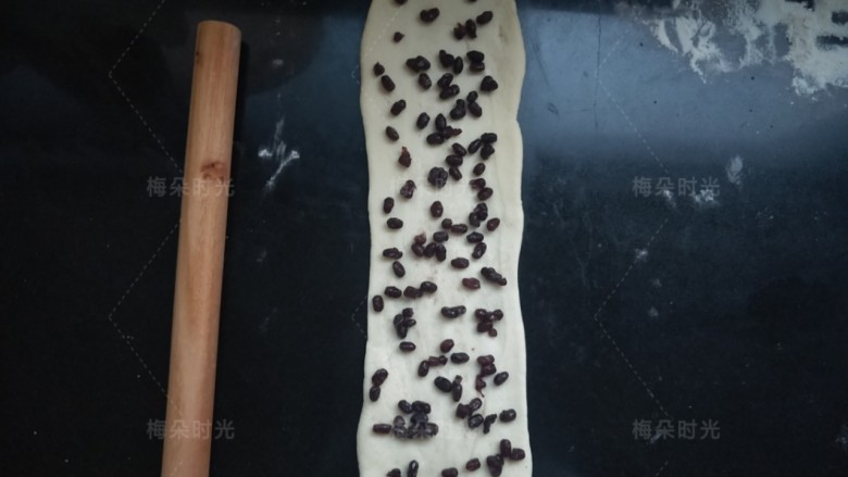 蜜红豆吐司,取一个面团擀成长条,撒上<a style='color:red;display:inline-block;' href='/shicai/ 8019'>蜜红豆</a>,卷起来